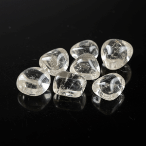 Polished tumbled Clear Quartz quartz silicate trigonal on black matte background, elegant crystal stones.