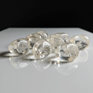 Polished tumbled Clear Quartz quartz silicate trigonal on white matte background, healing crystal stones.