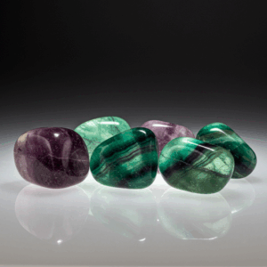 Polished tumbled Fluorite halide isometric cubic on white matte background, healing crystal stones.