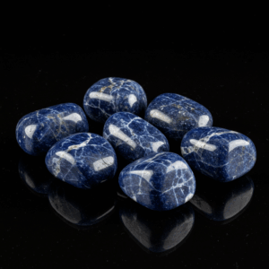 Polished tumbled Sodalite quartz silicate isometric on black matte background, elegant crystal stones.